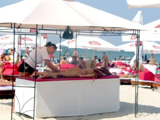 Turiştii obosiţi după o noapte în club au plătit să fie masaţi pe plajă